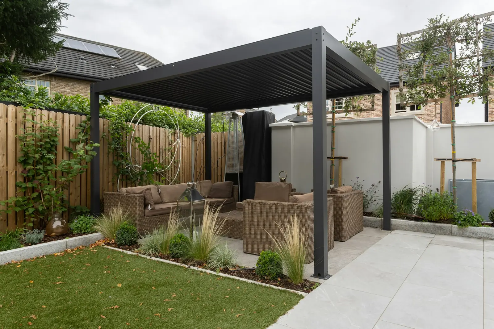 Porcelain terrace with a modern louvred pergola and outdoor sofa